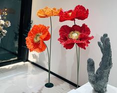 three vases with flowers in them on display