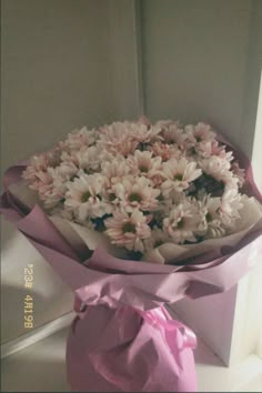 a bouquet of flowers is wrapped in pink paper