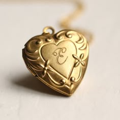 This beautiful vintage locket is a simple heart shape with an ornate Art Nouveau border, the perfect size for either an adult or child. The locket measures only 25mm (one inch) across and is made from solid brass. The size of this pendant means it can be worn by an adult or a child. I make each necklace to order and this necklace is available in a choice of chain lengths. Please refer to my illustration for a guide to how these lengths might look when worn. For girls under ten years, I would rec Initial Locket Necklace, Unique Locket Necklace, Locket Necklace Heart, Vintage Locket Necklace, Vintage Heart Locket, Locket Jewelry, Engraved Locket, Gold Heart Locket, Vintage Locket