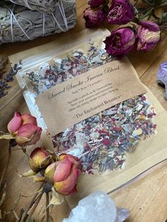 some dried flowers are sitting on a table next to an envelope with the wedding card