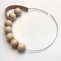 a wooden beaded bracelet on a white surface with a metal hook in the middle