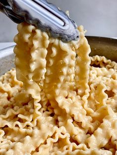 a ladle full of macaroni and cheese being stirred