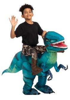 a young boy riding on the back of a dinosaur costume