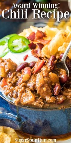 chili recipe in a blue bowl with chips and sour cream on the side that says, award winning chili recipe