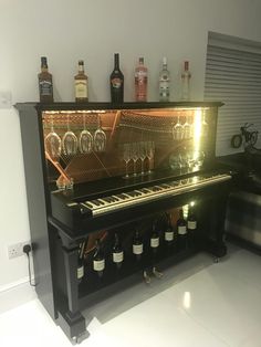 a piano with wine glasses and bottles on it