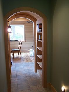 an archway leading to a dining room and living room with bookshelves on either side