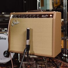 a guitar amplifier sitting on top of a table next to a microphone and amps