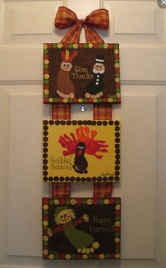 three thanksgiving cards hanging on the front door with a bow around it's neck