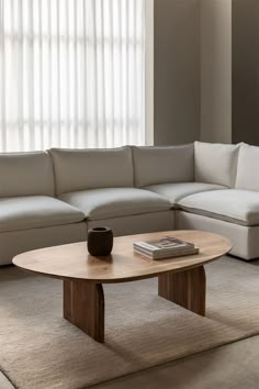 a living room with a sectional couch and coffee table in front of a large window