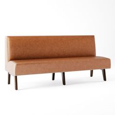 a brown leather couch sitting on top of a white floor next to a wooden frame