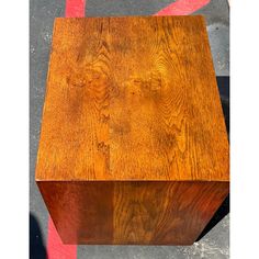 a wooden box sitting on the ground next to a red and white striped flooring