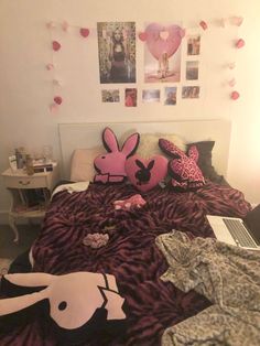 a bed covered in pink and purple sheets with pictures on the wall next to it