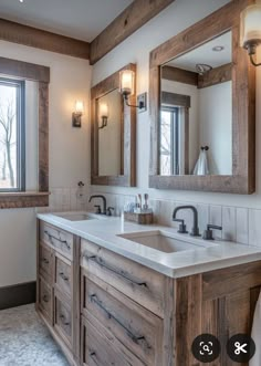 a bathroom with two sinks and mirrors in the corner, along with lights on either side of the sink