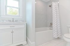 a white bathroom with a toilet, sink and bathtub