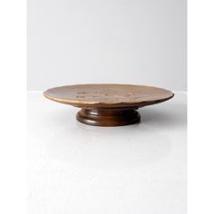 a small wooden plate sitting on top of a white table