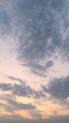 the sky is filled with clouds and there are two planes flying in the distance on the horizon