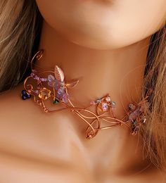 a close up of a mannequin wearing a necklace with flowers and leaves on it