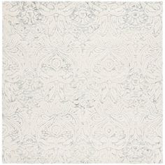 a white rug with an intricate design on the top and bottom corner, in grey tones