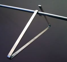 a pair of scissors hanging from a metal bar on top of a black tablecloth