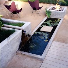 an outdoor patio with water features and chairs around the fire pit, as well as a fish pond