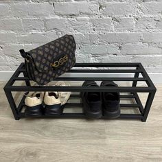 there is a shoe rack with shoes and a purse on it, next to a brick wall