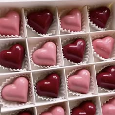 someone is holding a box of heart shaped chocolates