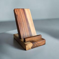 a wooden stand with a piece of wood sticking out of it's sides on a gray surface