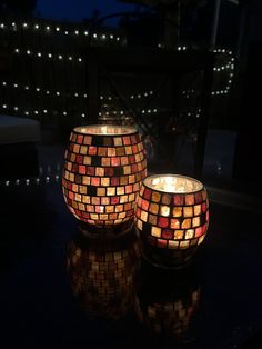 two lit candles sitting on top of a table