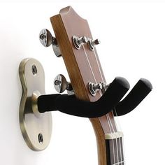 a guitar is hanging on the wall and has a hook for it's strings