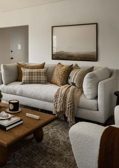 a living room filled with furniture and a coffee table in front of a painting on the wall