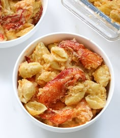 two white bowls filled with pasta and lobster