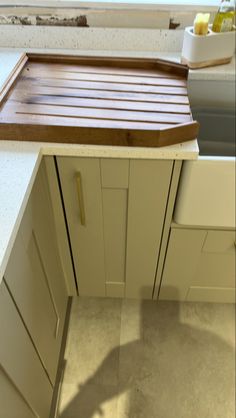 a wooden cutting board sitting on top of a kitchen counter next to an oven door