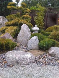 a rock garden with rocks and bushes around it