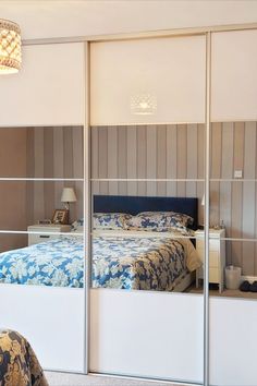 a bedroom with mirrored closet doors and a bed