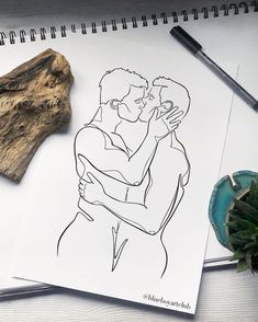 a drawing of two people hugging each other on top of a table next to a piece of driftwood