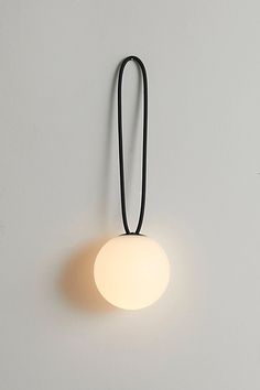 a light that is on the wall next to a white wall with a black cord