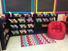 a classroom with blackboard and chalkboards on the wall, colorful rugs and chairs