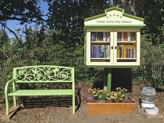 a green bench sitting next to a wooden book case and potted plant in front of it