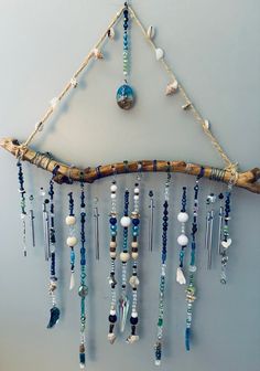 a wall hanging made out of driftwood and beads