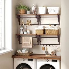 a washer and dryer in a room with open shelving on the wall