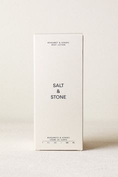 a white box sitting on top of a table next to a bottle of salt and stone