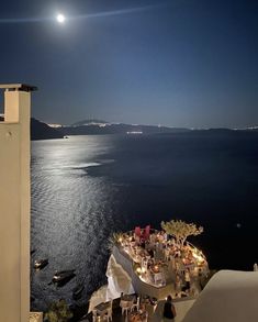 the moon is shining over an ocean and some buildings