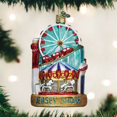 an ornament shaped like a ferris wheel hangs from a christmas tree with lights in the background