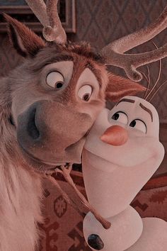 a close up of a cartoon character kissing another character with antlers on their head