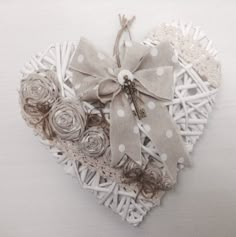 a heart shaped basket filled with flowers on top of a white table next to a pair of scissors