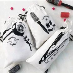 three bags filled with hair brushes on top of a white table next to a brush