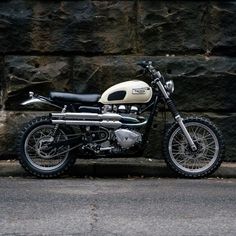 a motorcycle parked next to a stone wall