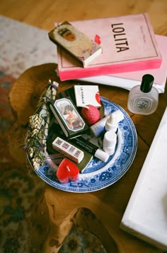 a table topped with books and cosmetics on top of a wooden table