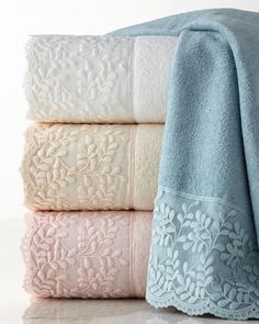 three towels stacked on top of each other with white and light blue trimmings