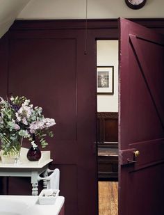 there is a vase with flowers in it on the table next to the sink and door